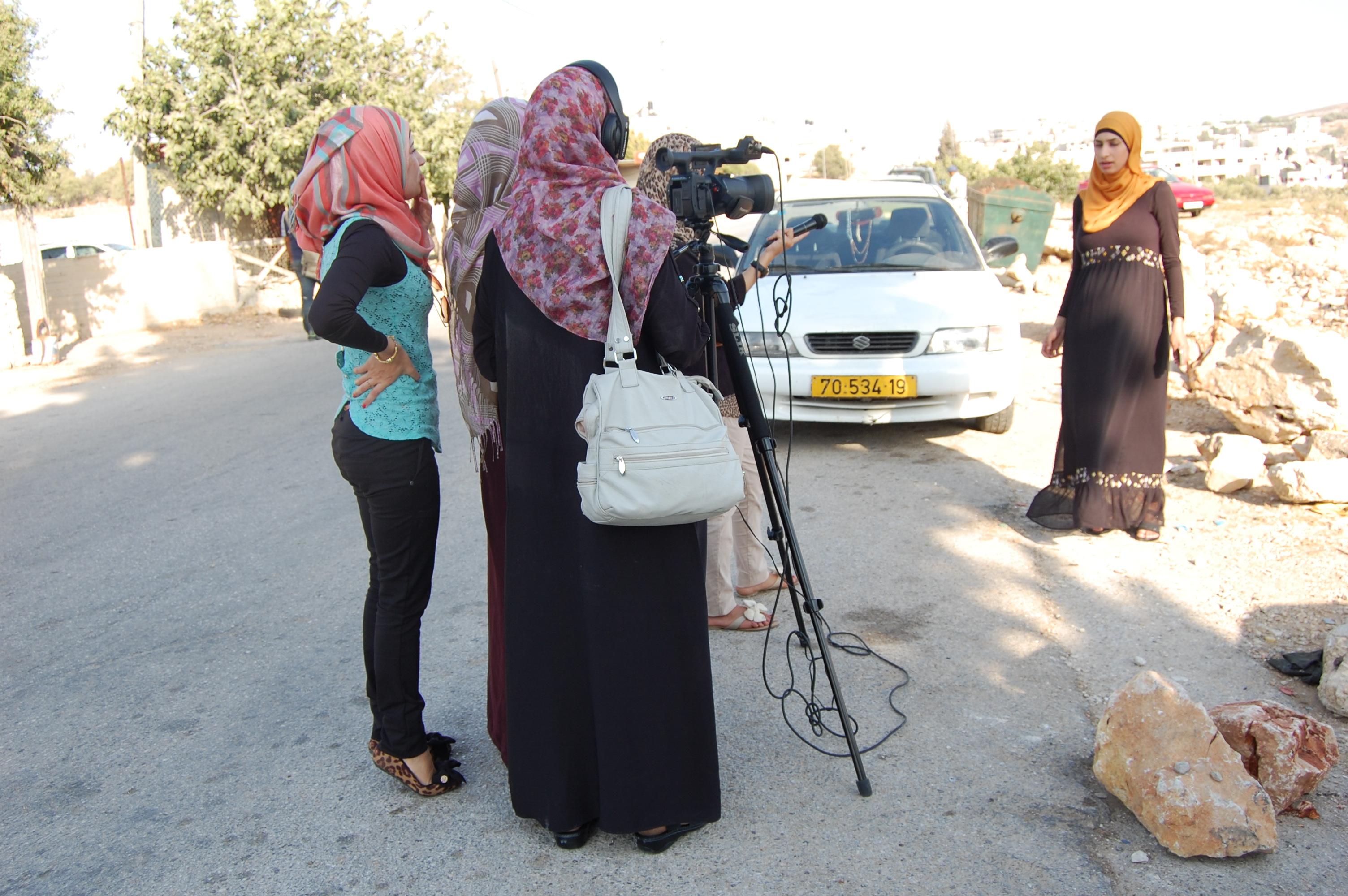 Film crew interviewing a community member outdoors