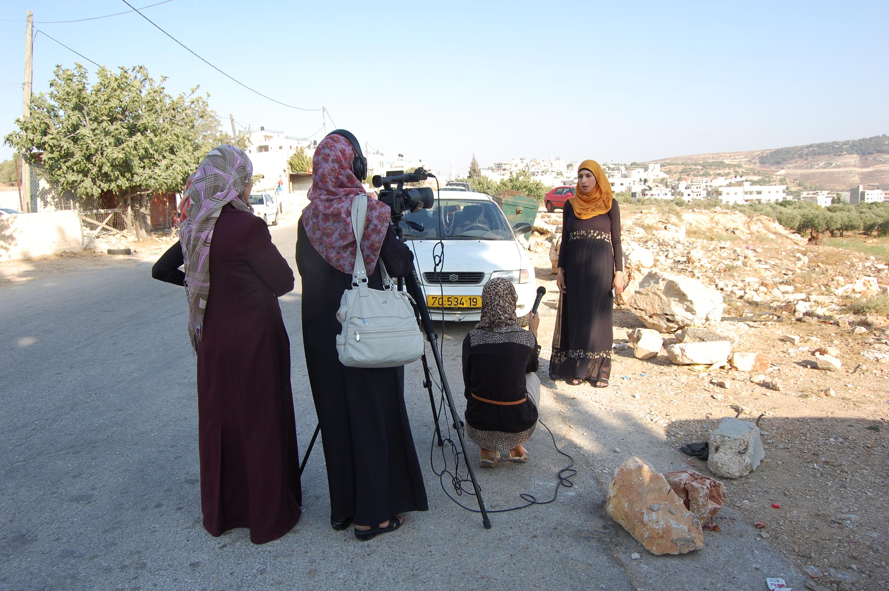 Women filming a community interview
