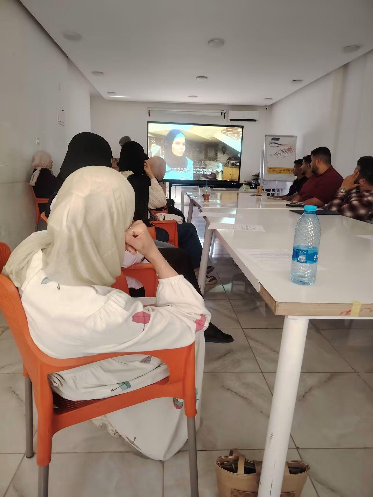 Audience members watching a MEND film screening in a community centre