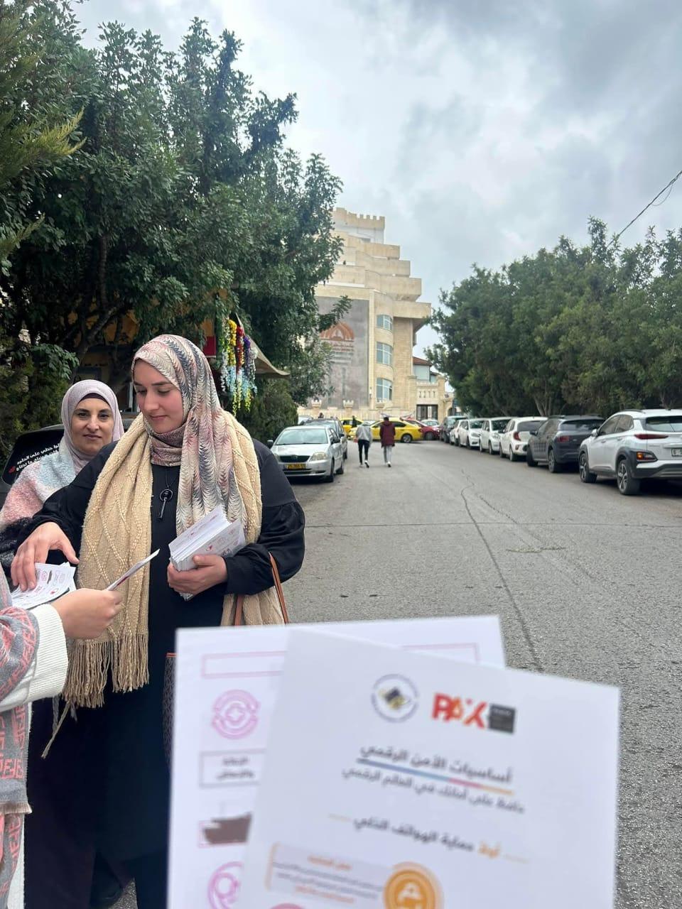Team members distributing awareness brochures on a Ramallah street