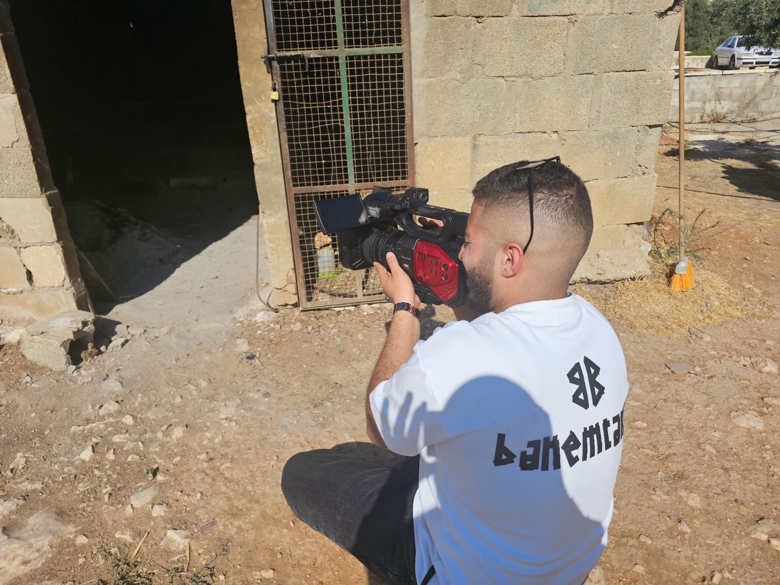 A videographer filming on location in a West Bank village